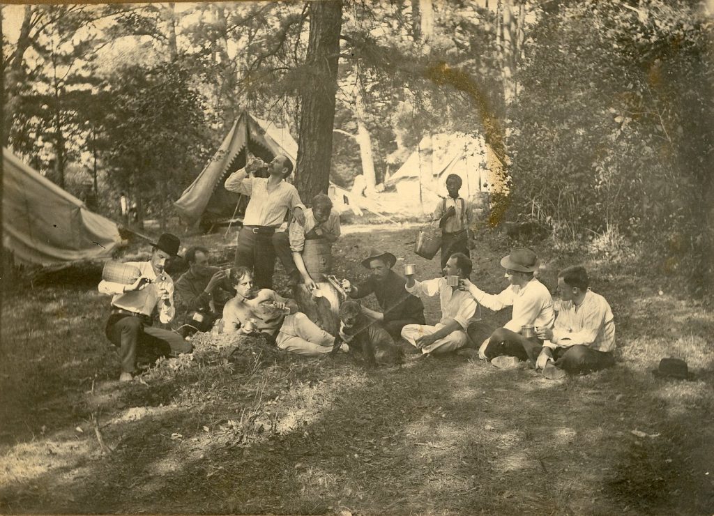 A Camp Outing - group of men are drinking at a camp site